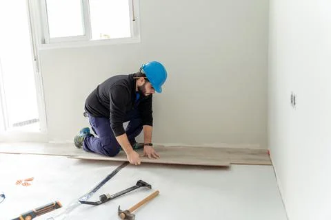 Man worker assembling laminate flooring. Stock Photos