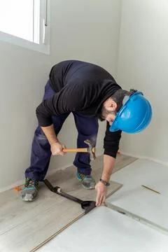 Man worker assembling laminate flooring. Stock Photos