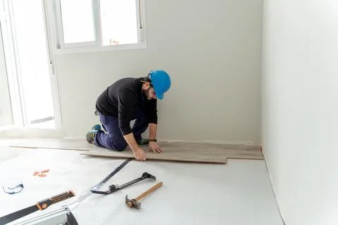 Man worker assembling laminate flooring. Stock Photos
