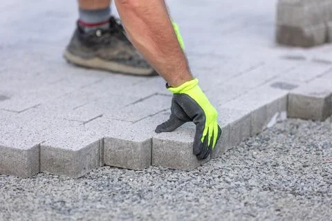 Man worker building a new path from concrete pavement, building concept Stock Photos