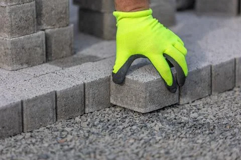 Man worker building a new path from concrete pavement, building concept Stock Photos
