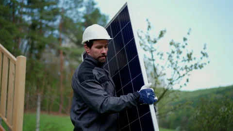 Man worker carrying solar panel for installing solar modul system on house. Stock Footage 200781409