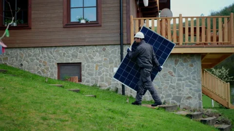 Man worker carrying solar panel for installing solar modul system on house. Stock Footage 200782150