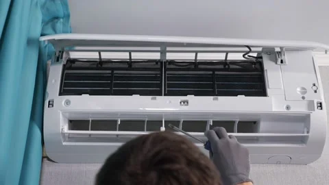 Man worker checks air conditioner lid and extracts screws Stock Footage 153035386