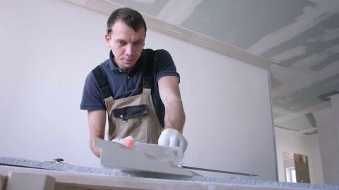 Man worker cuts decorative fretwork with orange handle saw Stock Footage 151784484