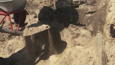 Man worker digs a hole in the ground with a shovel and puts it in a cart. grave Stock Footage 136458879