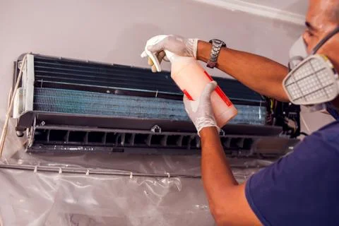 Man worker doing professional cleaning of air conditioning. Stock Photos
