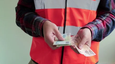 Man worker dressed in a reflective vest count arab money dirhams. Hands closeup Stock Footage 107220081