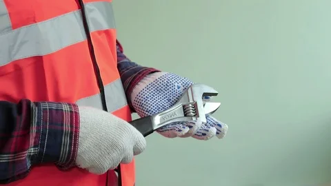 Man worker dressed in a reflective vest hold adjustable wrench, 스톡 동영상 107256713