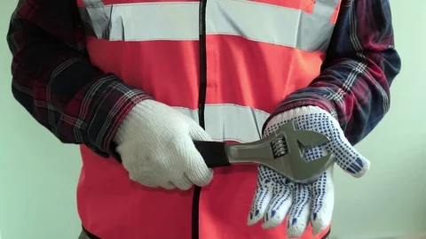 Man worker dressed in a reflective vest hold adjustable wrench Stock-Footage 107256719