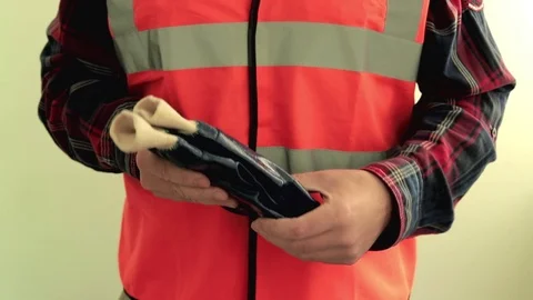 Man worker dressed in a reflective vest put on blue waterproof protective gloves Stock-Footage 107426115
