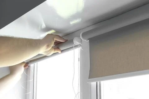 Man worker hands installing attaching mounting bracket on roller blinds, shad Stock Photos