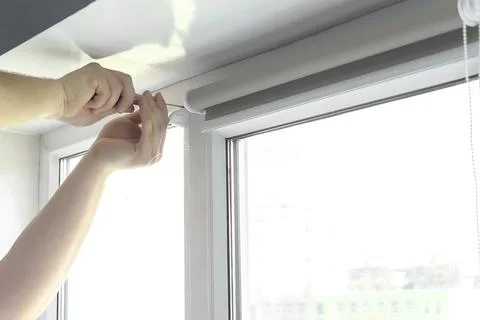 Man worker hands installing attaching mounting bracket on roller blinds, shad Stock Photos