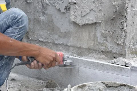 Man worker hands using electric grinder cutting stone. Foto stock