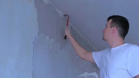 Man worker knocks on wall with crowbar removing irregularities makes plastering. Video stock 123349072