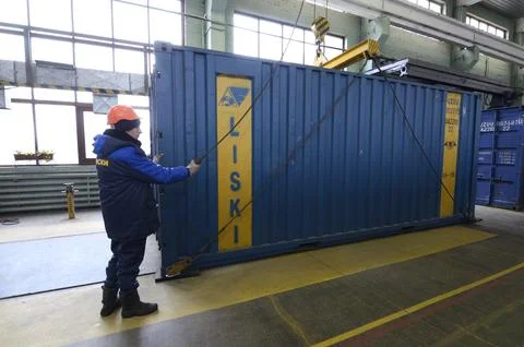 Man worker lifting cargo container for repairing using the hoist crane. Mai.. Stock Photos