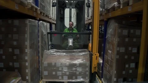 Man worker lifting cargo using loading equipment during working day at warehouse Stock Footage 127674815