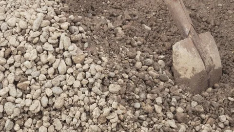 A man, a worker, loads sand and gravel mixtures into a garden wheelbarrow for Stock Footage 288178121