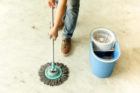 Man worker with mop cleaning floor in the cafe. Stock Photos