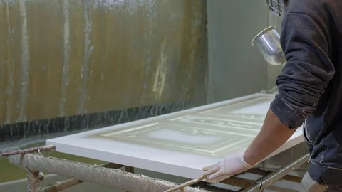 Man, worker paints the door. The process of making wooden doors. production of Stock Footage 98326998