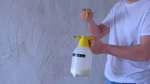 Man worker prepares sprayer with primer to renovation works, hands closeup. Stock Footage 123346817