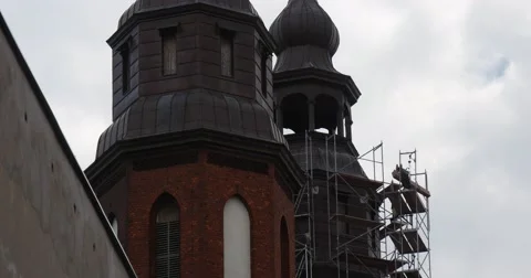 Man Worker on a Scaffold Around Towers of Cathedral Walls of Tower of Red Stock Footage 53832090