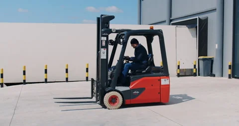 Man worker sitting in forklift loader in industrial warehouse. Slow motion. Stock Footage 171807323
