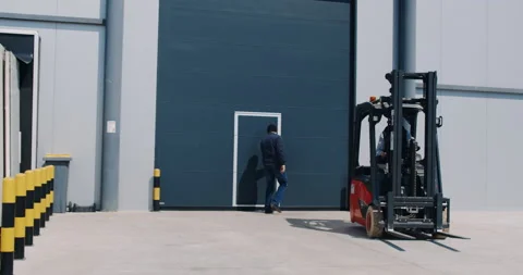 Man worker sitting in forklift loader in industrial warehouse. Slow motion. Stock Footage 172196385