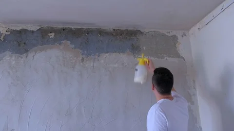 Man worker spraying primer to wall prepare it to plaster renovation, back view. Video stock 123347243