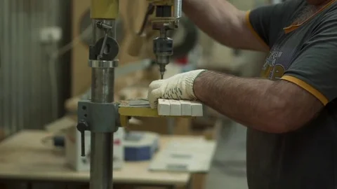 A man worker stands by the machine. The worker is drilling the part Stock Footage 84043128