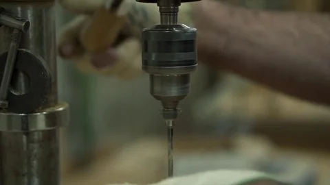 A man worker stands by the machine. The worker is drilling the part Stock Footage 84043140