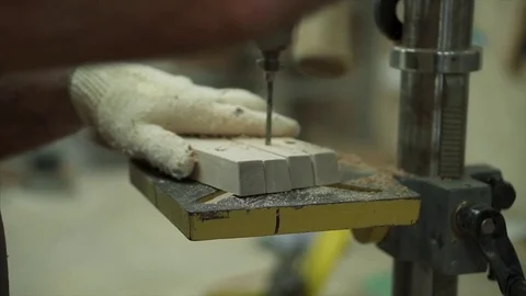 A man worker stands by the machine. The worker is drilling the part Stock Footage 84043147