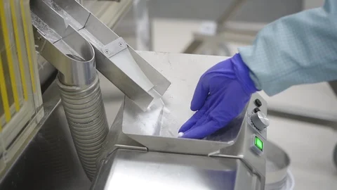 Man worker taking white pills in hand while work day in pharmaceutical factory. Видео 119927589