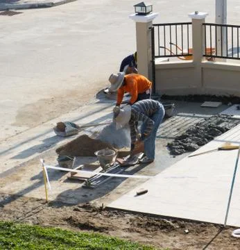 Man worker tiling ceramic floor Stock Photos