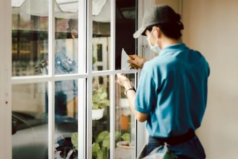 Man worker tinting window with foil indoor. Foto stock