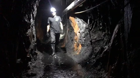 Man worker walks in mine (cell phone footage) Stockbeeldmateriaal 105076673
