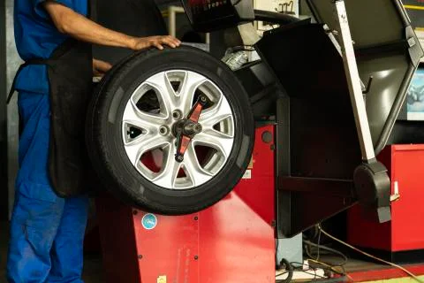 Man worker with Wheel balancing machine for car tire repair service. Stock Photos