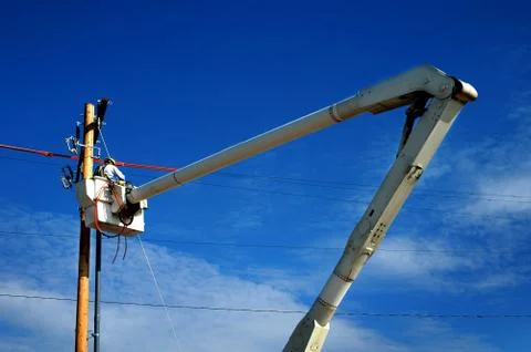 Man Worker Working on Power Lines Crane Bucket High in the Air Dangerous Stock Photos