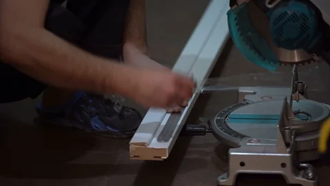 A man (worker/Builder) makes a tick / mark on a white wooden Board with a ruler  Stock Footage 104027909