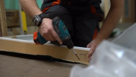 Man / worker/person using a screwdriver screws the screw  Stock Footage 104028065