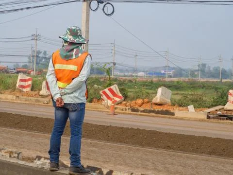 Man workers stand to control the road construction Stock Photos