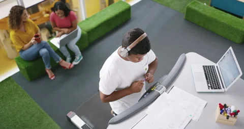 Man, working and music with technology and treadmill for planning, writing and Stock Footage 258366682