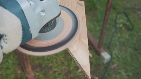 The man is working with angle grinder for the grinder of the wooden board. Stock Footage 130384740