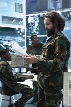 Man working in army headquarters reading printed documents Stock Photos