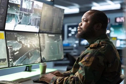 Man working as army operator reviewing surveillance feeds Stock Photos