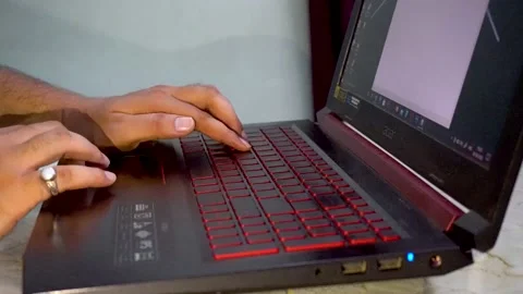 Man working on back light keyboard of laptop with red light Stock Footage 207057774