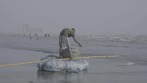 A man working on the beach in Karachi, Pakistan Stock Footage 343875644