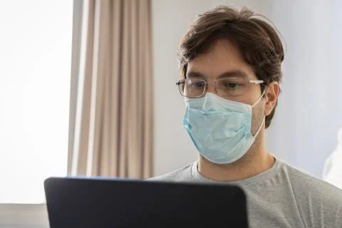 Man working in bed, doing home office because he is sick. Stock Photos