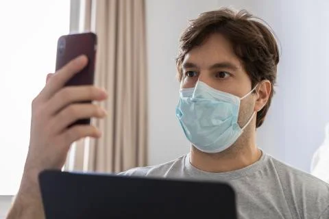 Man working in bed, doing home office because he is sick. Stock Photos