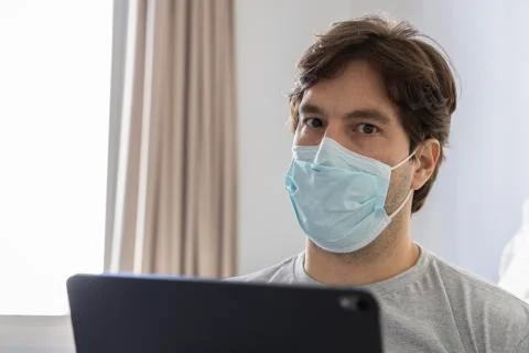 Man working in bed, doing home office because he is sick. Stock Photos